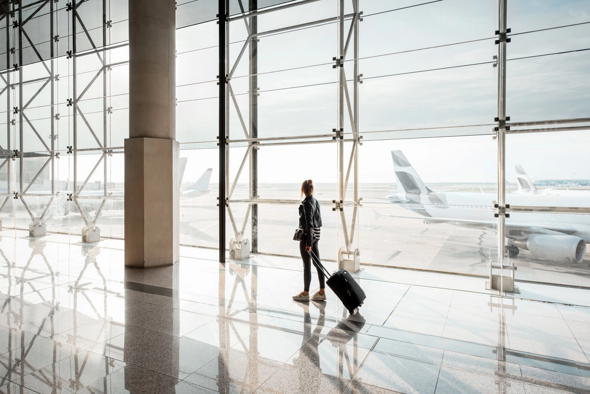 view-aiport-window-with-woman-walking-with-suitcase